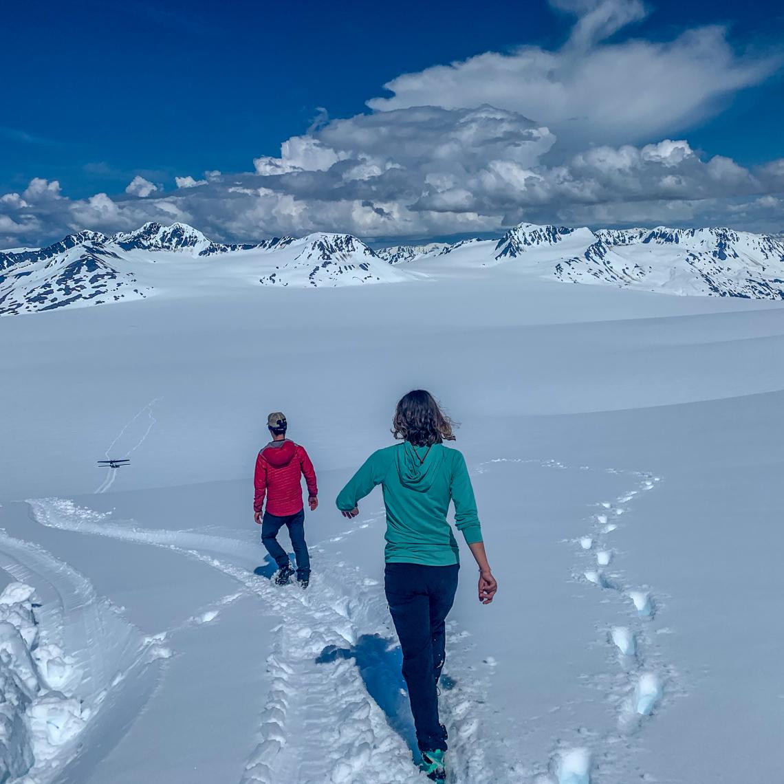 walking on icefield with ski plane